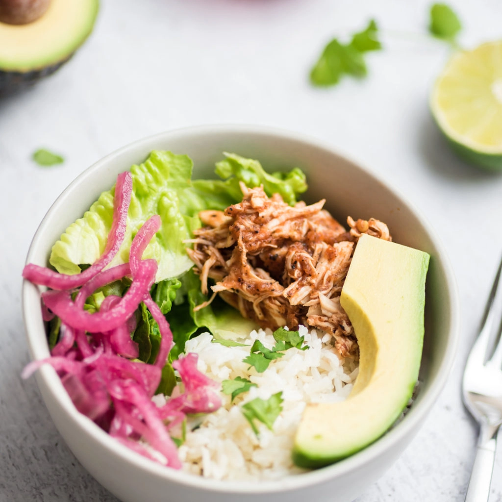 bowl with rice, avocado, green chili chicken, onion