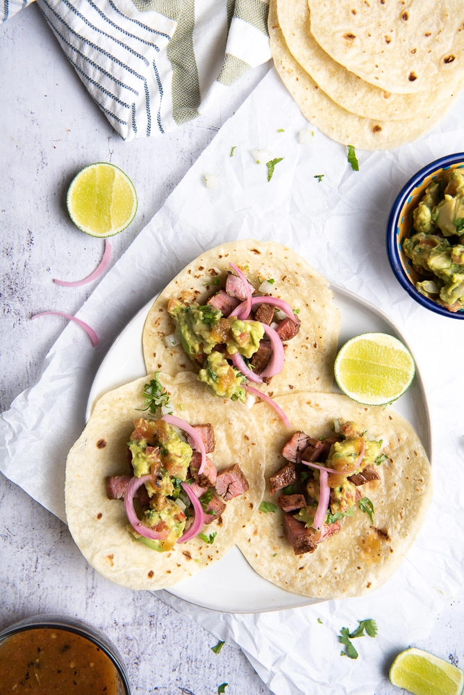 tacos with lime and onions on a plate