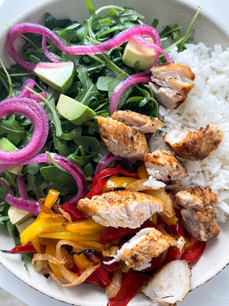 CHICKEN, ONIONS, PEPPERS, ARUGULA, AVOCADO AND RICE BOWL