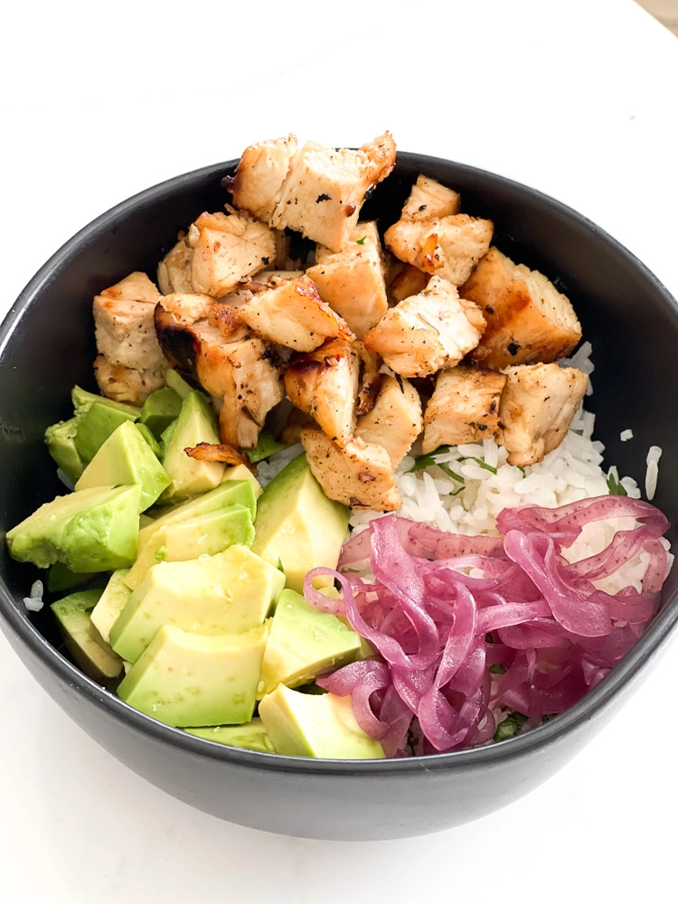 chicken, rice, avocado, pickled onion in a bowl