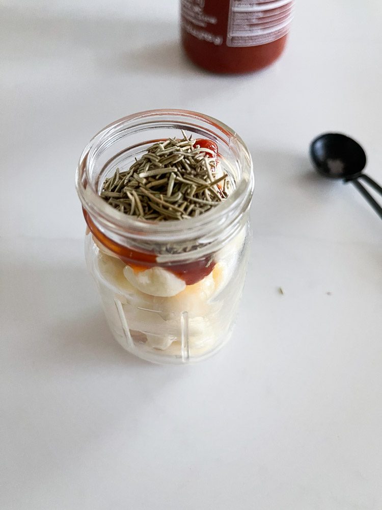 garlic in a jar with sriracha and thyme