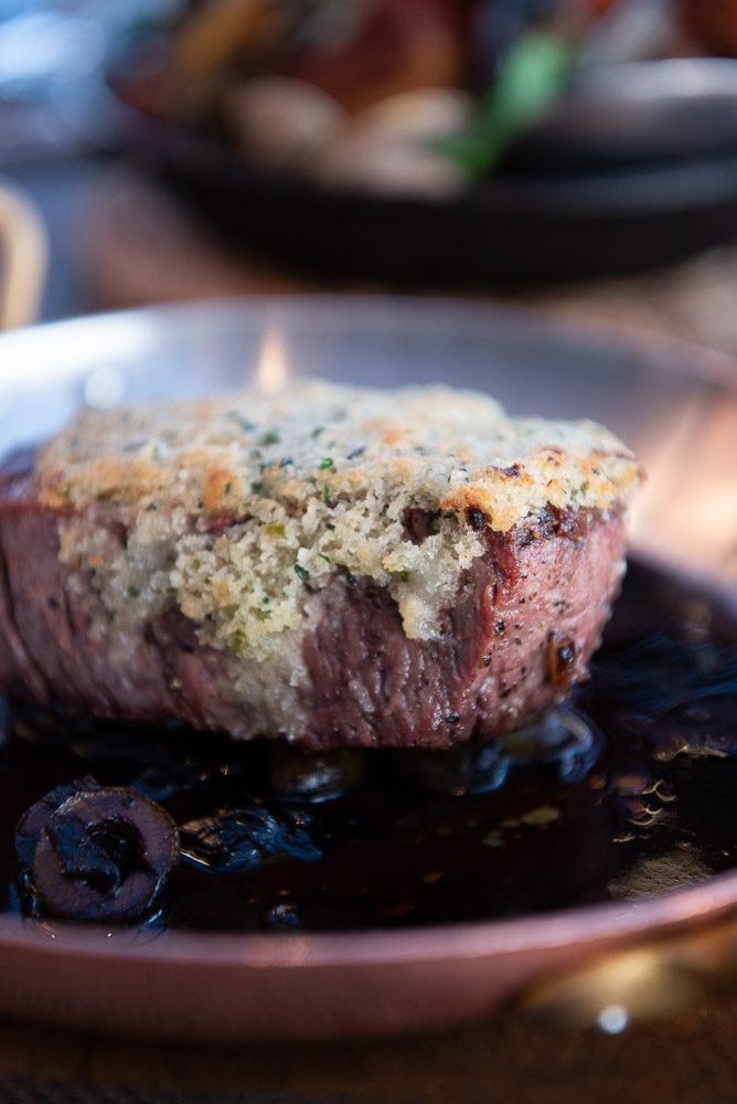 steak on plate crusted with Manchego cheese