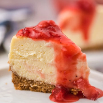 Strawberry cheesecake slice on plate with strawberry jam