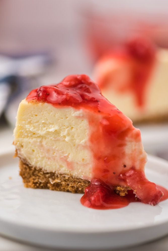 strawberry cheesecake with sauce in white plate