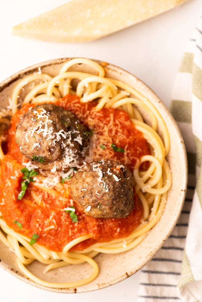 meatballs, spaghetti and marinara sauce on plate with cheese