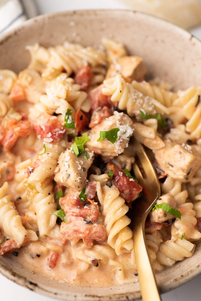 rotini pasta in a bowl with creamy sauce and fork