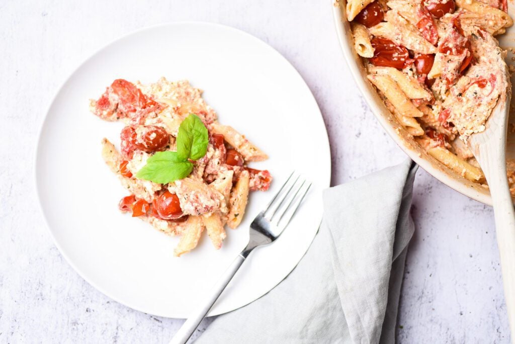 pasta on plate and pasta on baking dish with wooden spoon