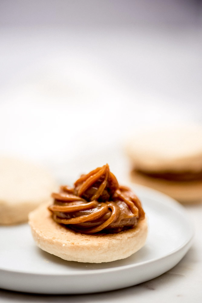 Alfajor on a plate topped with Dulce de Leche