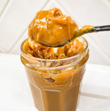 Dulce de leche in jar with spoon