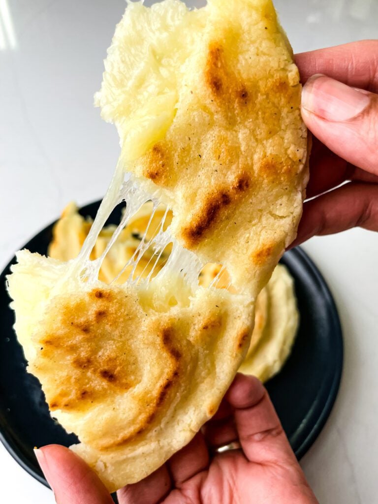 Colombian cheese arepa on a plate, split open