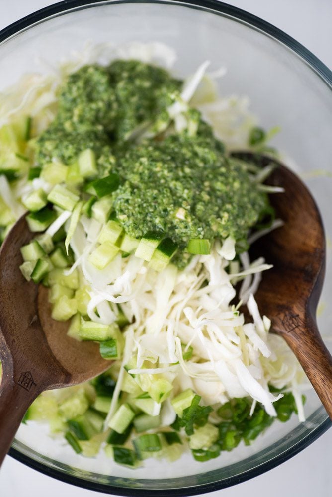 cabbage with green goddess salad dressing and wooden spoons on a bowl