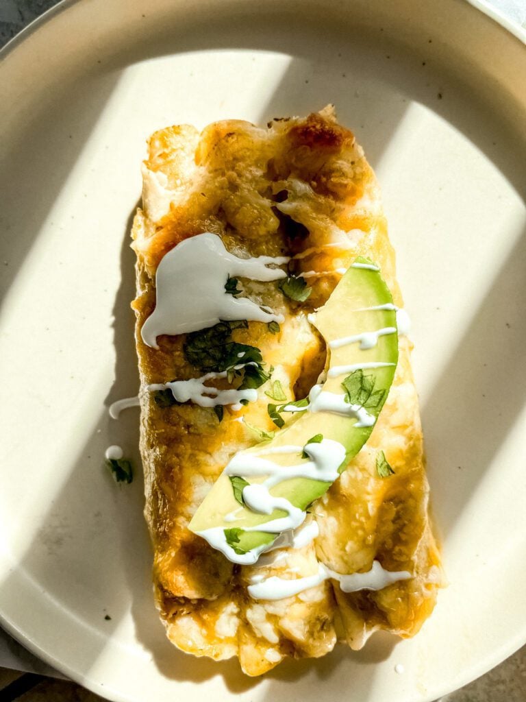 Enchiladas on plate with green sauce