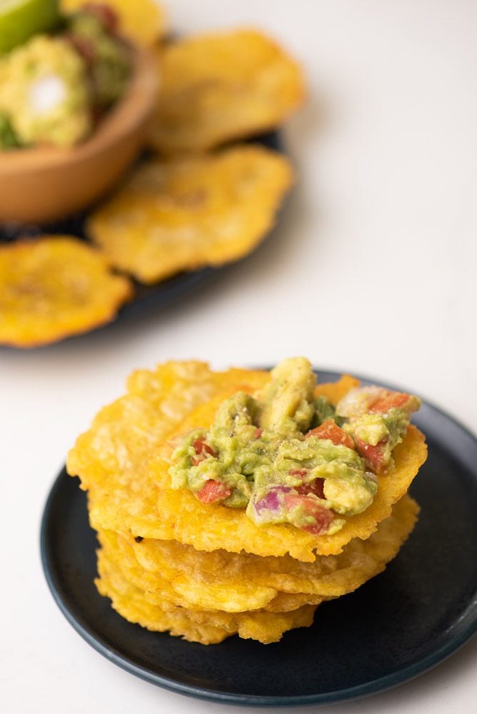 tostones on a stack with guacamole.