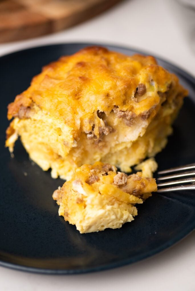 breakfast casserole slice on a blue plate with fork