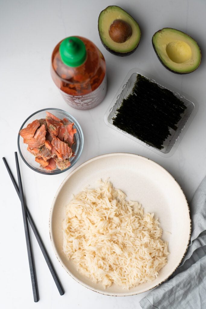 Salmon bowl ingredients: Salmon, rice, sriracha, avocado, seaweed.