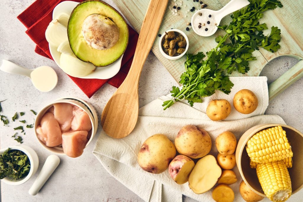 Ingredients for Colombian ajiaco: chicken, potatoes, corn, capers, avocado, cream, guasca leaf (native of Colombia)