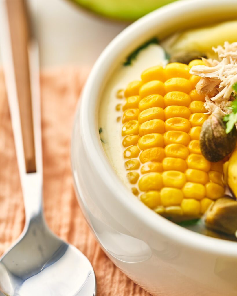 Ajiaco in a bowl with corn and capers