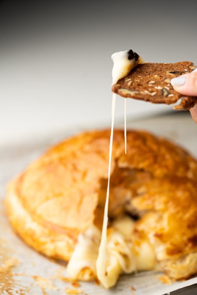 Baked Brie en croute on baking sheet with crackers