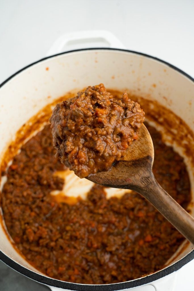 Bolognese sauce on a pot with wooden spoon