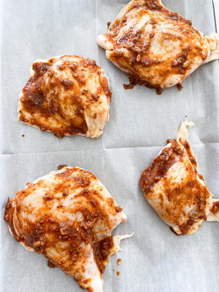 Chicken thighs with marinade on a sheet