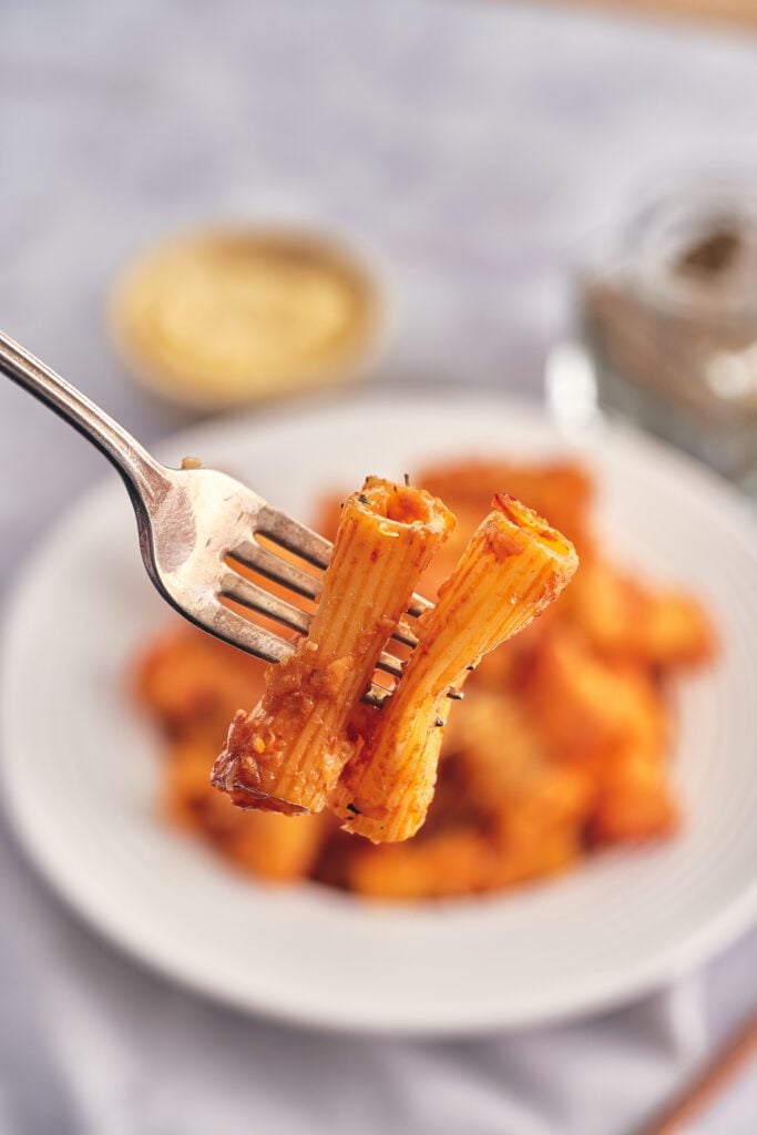 pasta on a fork with plate in the background