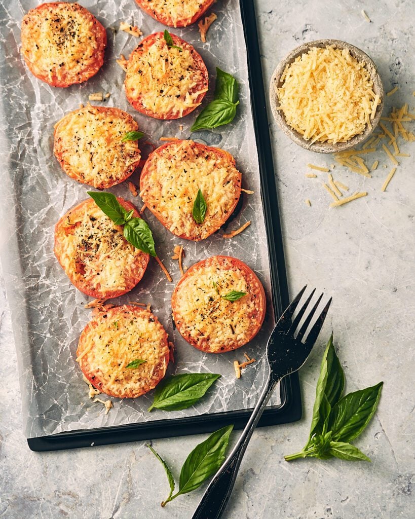 tomatoes on a sheet tray with basil