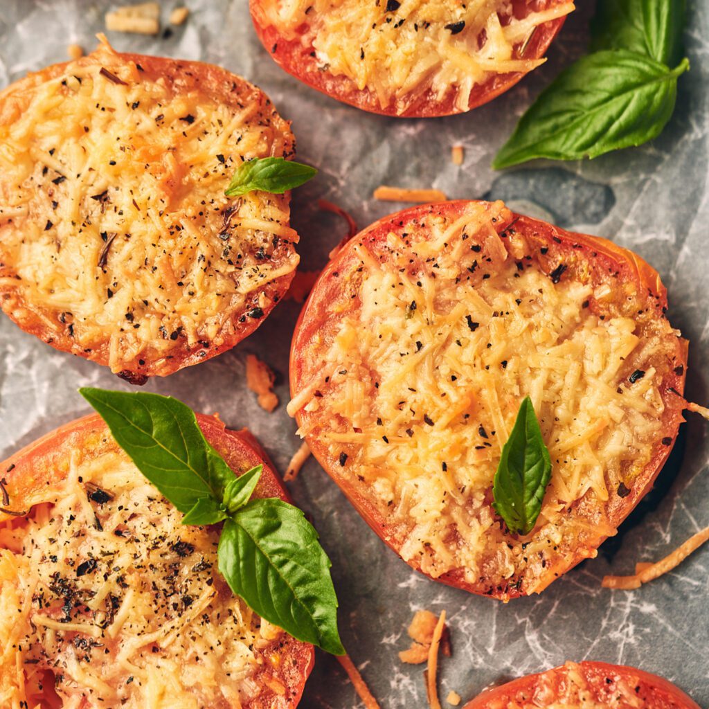 overhead view of tomatoes topped with basil and parmesan
