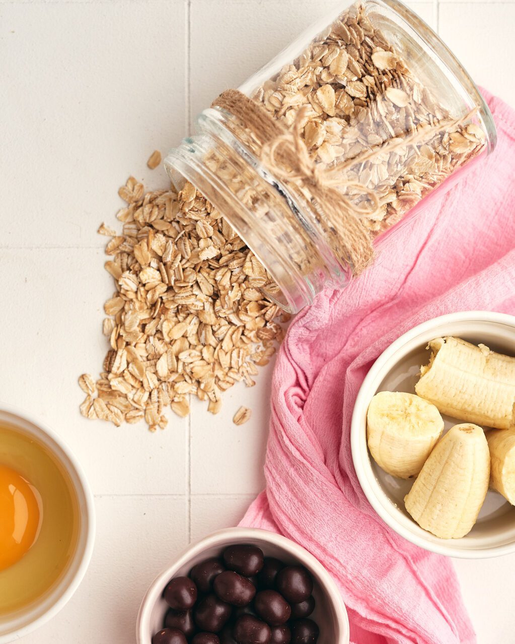 oats, egg, banana and blue berries in bowls with napkin underneath 