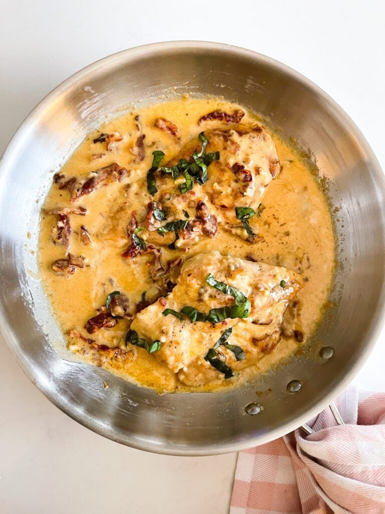 overhead shot of chicken in creamy sauce in a pan