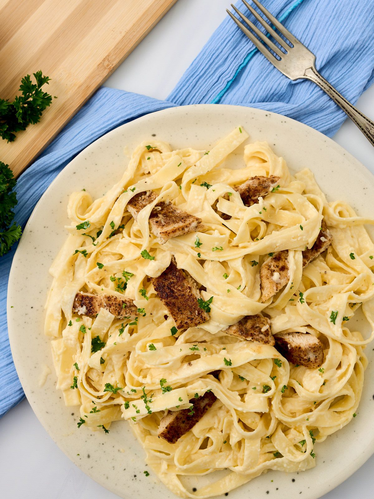 plate with creamy pasta and blackened chicken