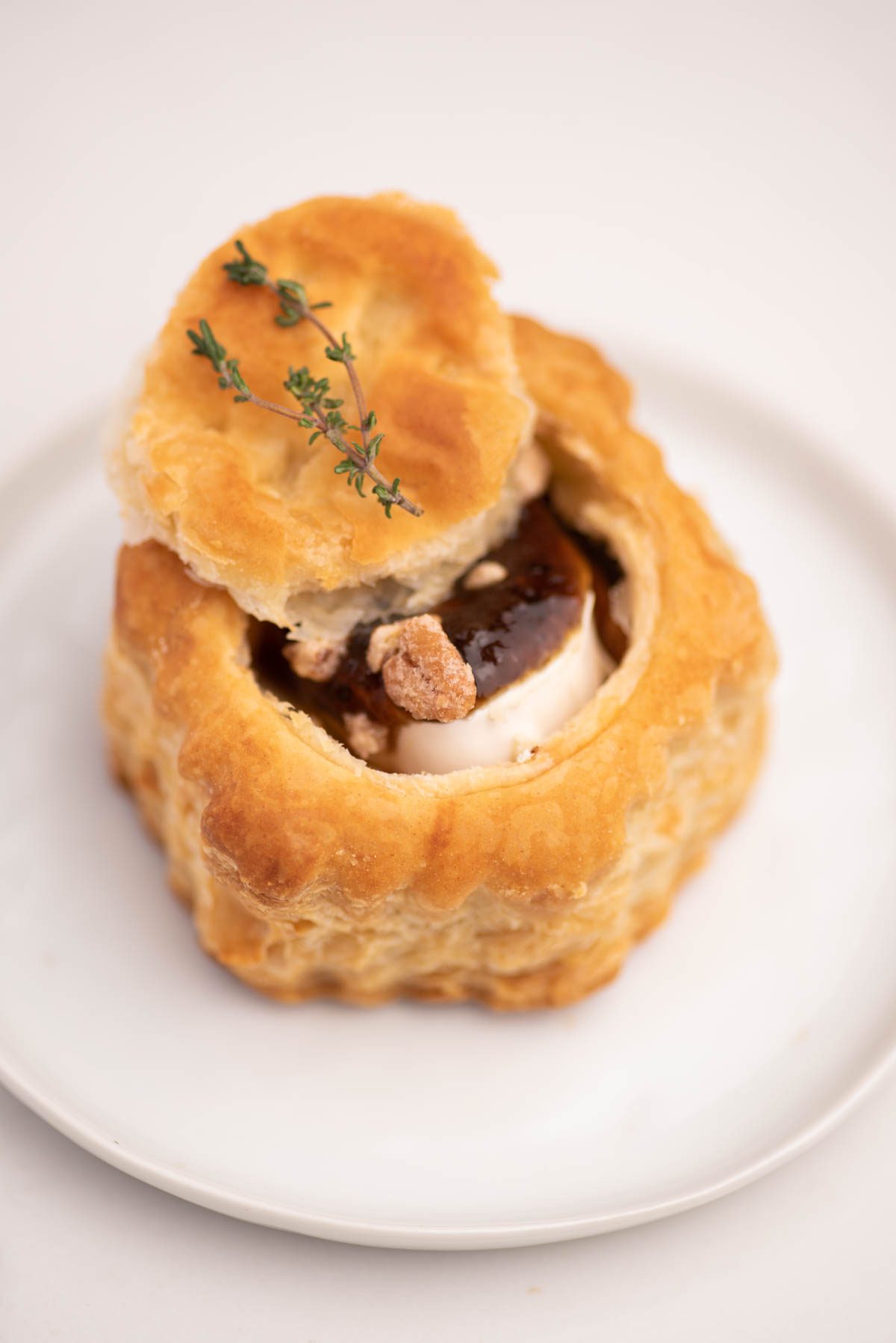 puff pastry with brie and jam on a white plate.