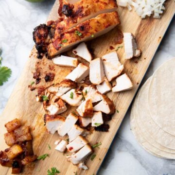 Al pastor chicken on a cutting board.