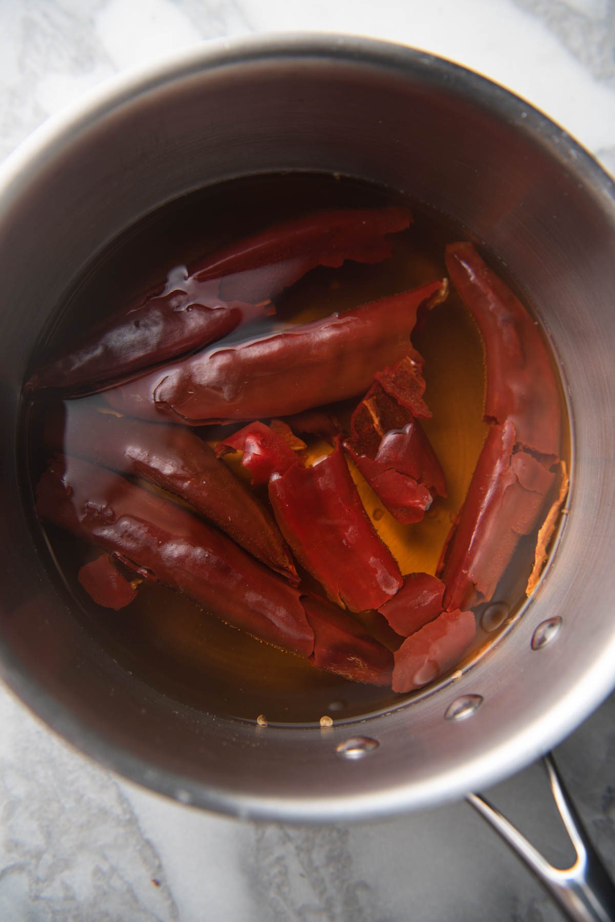 peppers in water on a sauce pan.