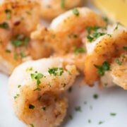 Shrimp on a plate with parsley and lemon.