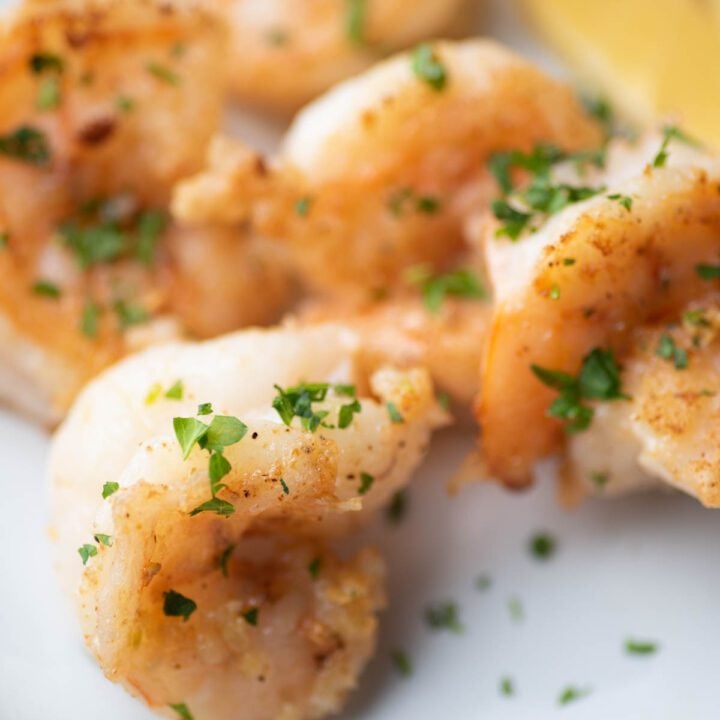 shrimp on a plate with parsley and lemon