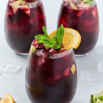 Red sangria with orange slices and mint served on a glass