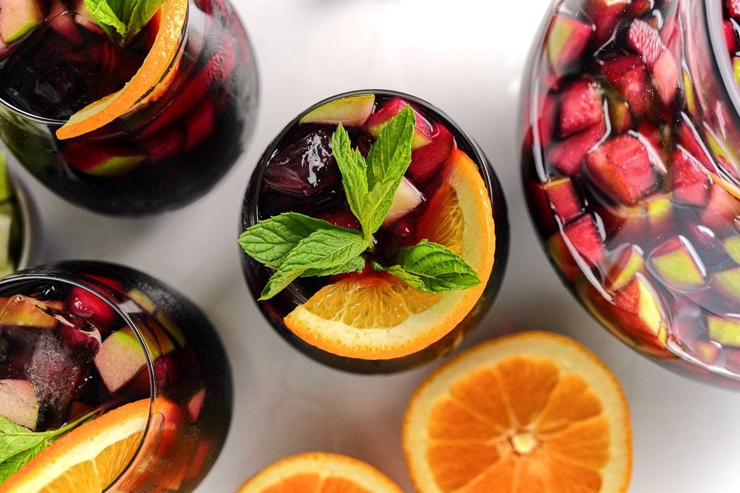 Sangria with orange slices and mint in wine glasses.