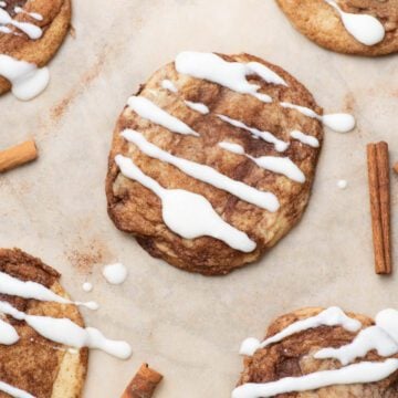 Cinnamon roll cookies on payment paper with cinnamon sticks.