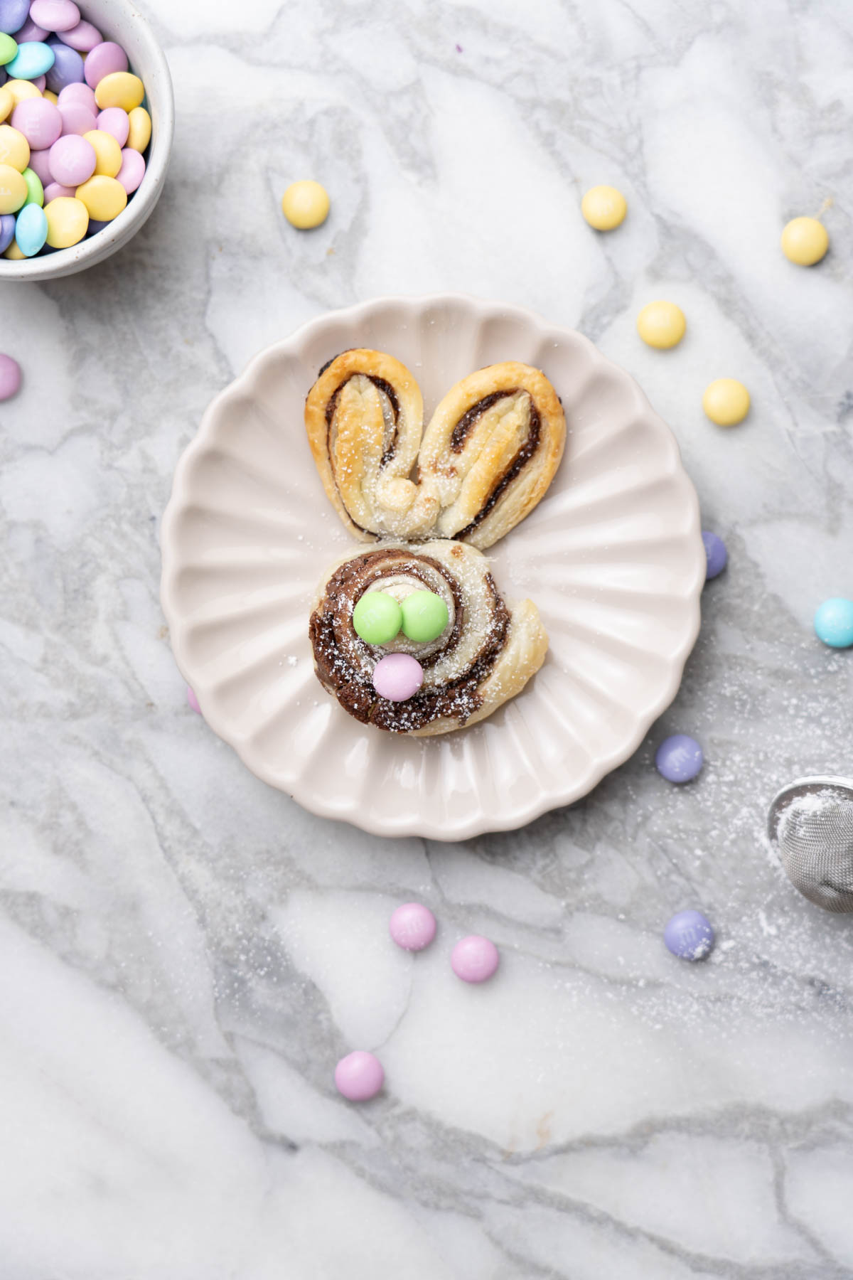 Puff pastry bunny with M&M's on a plate.