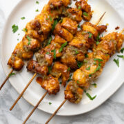 Garlic parmesan chicken skewers with parsley.