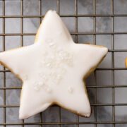 Cookies on a cooling rack with royal icing and sprinkles.