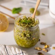 Easy Castelvestrano Olive Tapenade in a jar with wooden spoon.