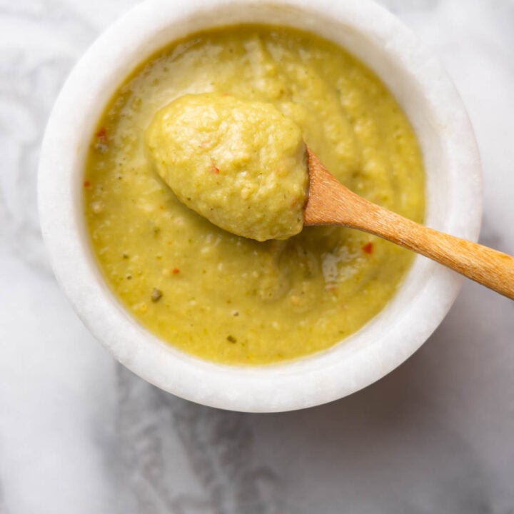 Guacasalsa recipe in a white bowl with wooden spoon.