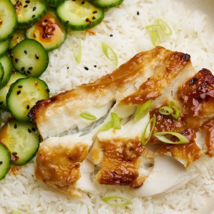 Miso glazed cod with cucumber salad and rice on a bowl.