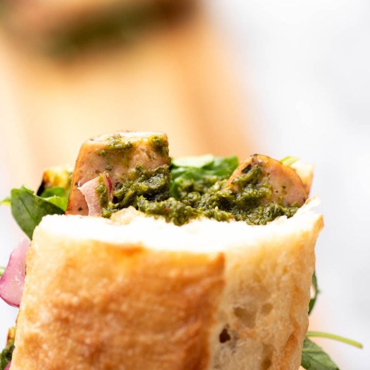 Argentinian choripan with sausage, chicmichurri and pickled onions.