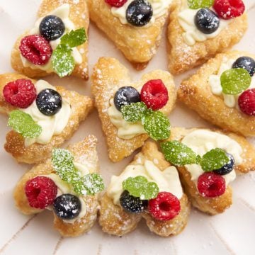 Puff pastry filled with cheesecake and berries. Garnished with mint and powdered sugar.