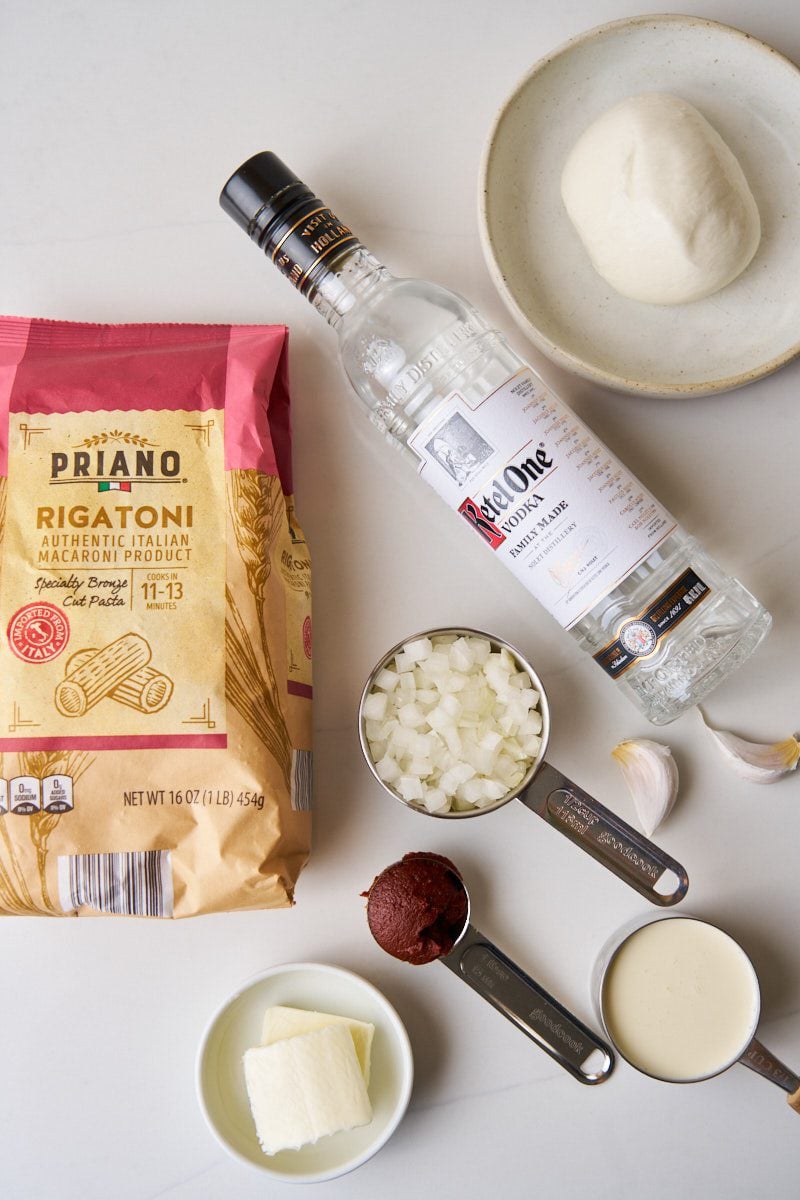 Ingredients for creamy rigatoni alla vodka topped with burrata and basil.