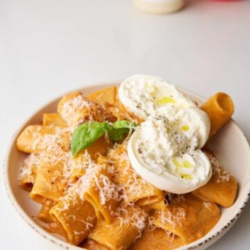 Paccheri rigati pasta with burrata cheese and basil.